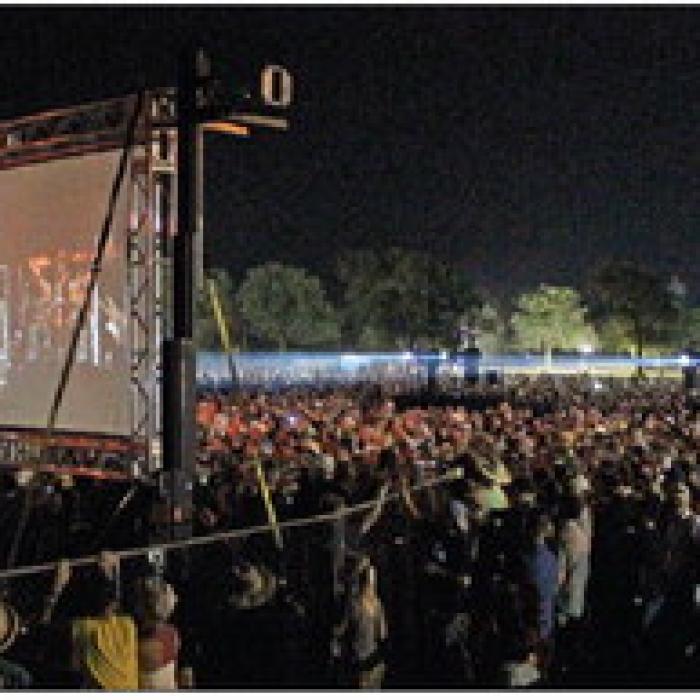 This photo shows the expanse of people and one of the portable video screens that were set up in a field in the fairgrounds parking lot where an estimated 18,000 people watched the concert. Photo by Jeff Wick