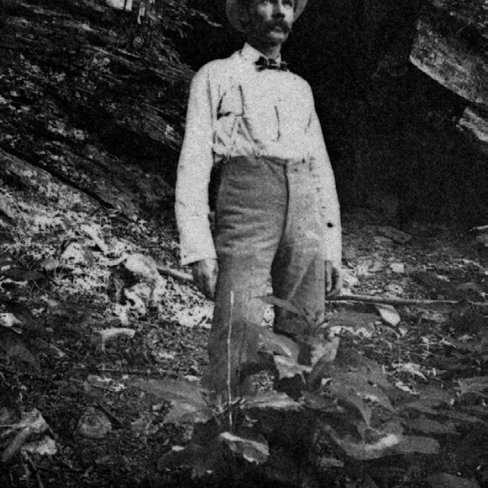 Frank Hausmann standing below the bluff, courtesy of the Fayette Heritage Museum and Archives.