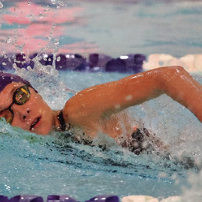 Eleanor Carey is shown here setting a new school record in the 100 yard freestyle with a time of 1:04.53. Photo by Katy Michalke