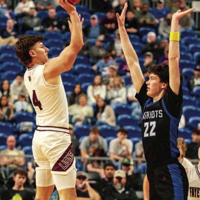 Fayetteville’s Jack Schley takes a jump shot over the 6-foot-10 Turkey Valley senior Kanyon Taylor. Photo by Andy Behlen