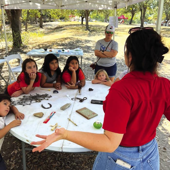 Educator Railey Tassin uses interpretation techniques with students at Archeology Day.