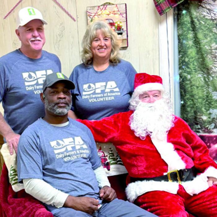 The volunteers from Dairy Farmers of America with Santa. Johnny Osborn and Jackie Vornsand in the rear with Leon Brooks sitting with Santa.
