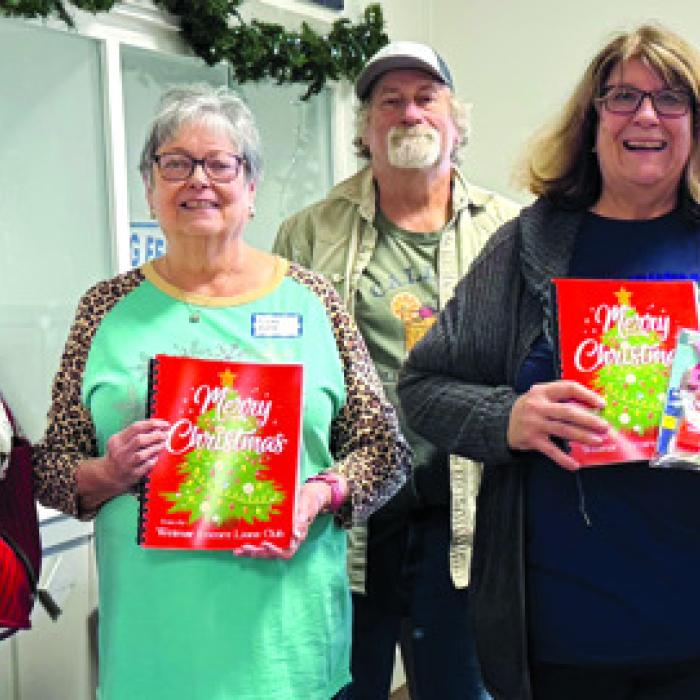 Weimar Encore Lions Club donated these fun activity books for the members at the Christmas Party. They came with coloring tools, too. Pictured are Nancy Parrish, Linda Heller, Tommy and Denise Koenig, and Senior Connections Executive Director and head chef Amanda Kridel.
