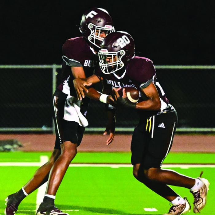 Quarterback Jaylon Anderson hands off to Adrian Anderson Friday night in Flatonia. The Flatonia Bulldogs beat the Three Rivers Bulldogs in a non district game Friday night. The Bulldogs will begin district action this Friday in Flatonia when they host Ganado. Photo by Stephanie Steinhauser