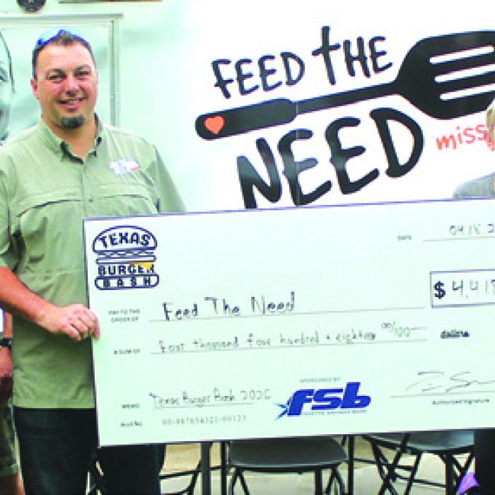 Texas Burger Bash Board Members and Winners present proceeds from this year’s event at a Monday Feed the Need distribution in downtown La Grange. Photo by Jeff Wick