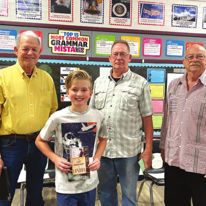 Book club members Mike Clann, John Dennis and Evan Quiros are pictured with Fayetteville 5th grader, Knox Farley.