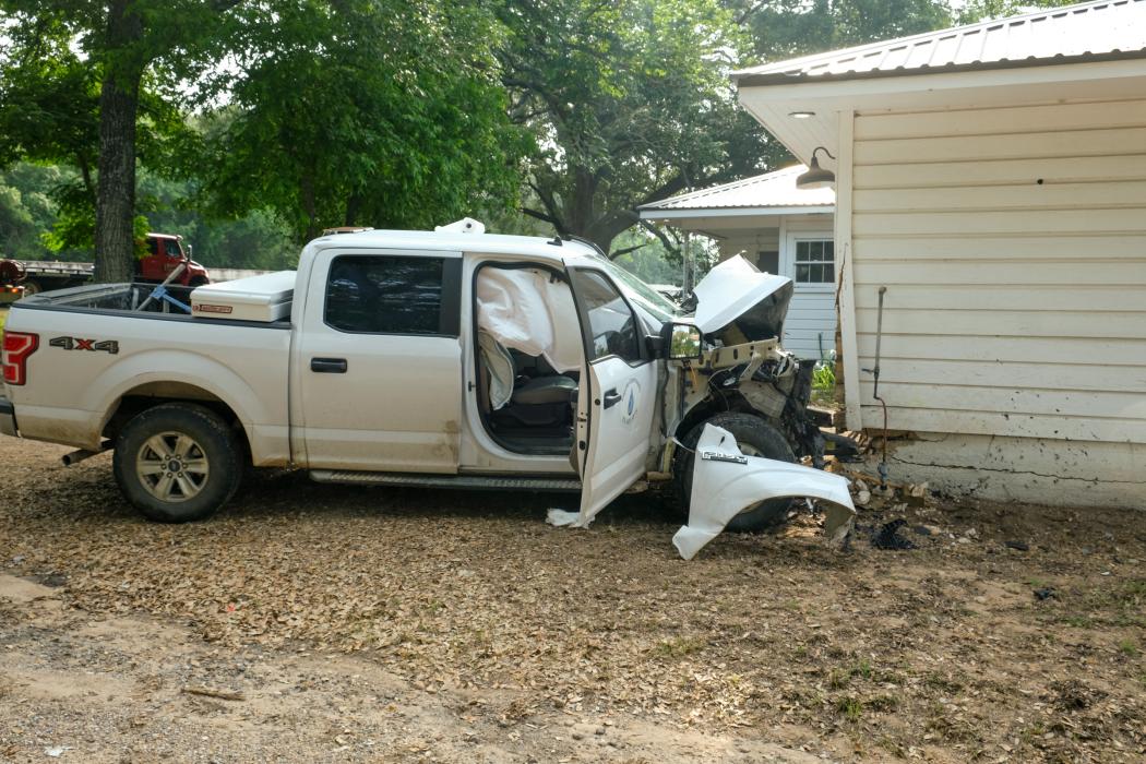A white Ford pickup owned by Fayette Water Supply Corporation crashed into a Range Rover and then struck a house located a short distance off the highway.