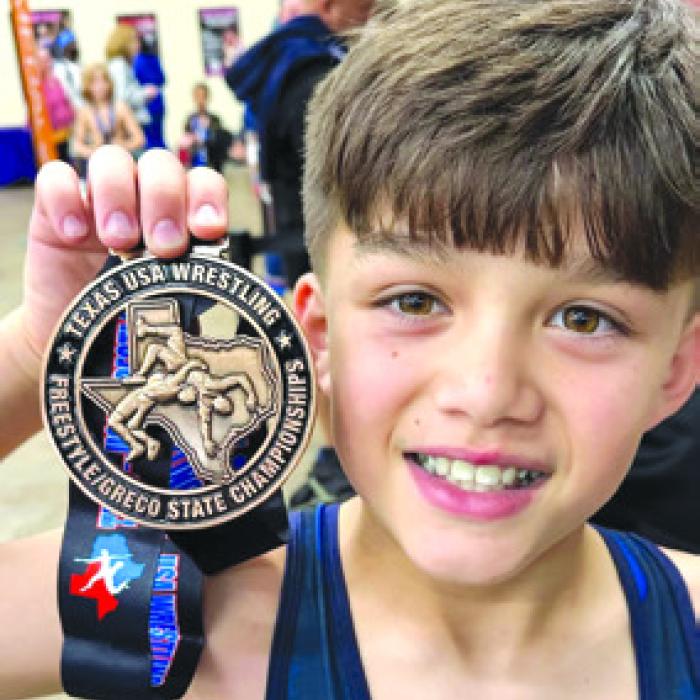 Kathy and Frank Chlumsky’s grandson Hunter Dong with his 3rd place state metal.
