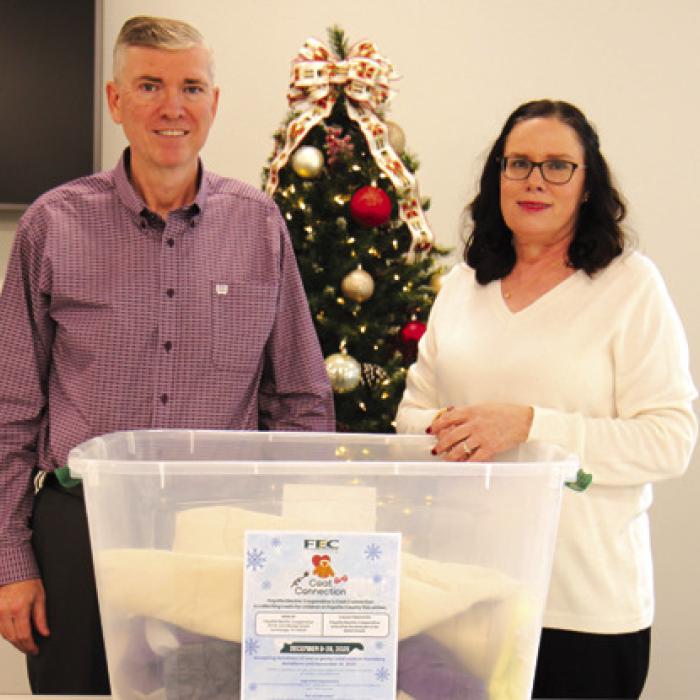 FEC General Manager Doug Lambert and Director of Marketing, Training, and Communication Tracy Denton display some donations collected for FEC’s Coat Connection coat drive, an effort to provide warmth to children in need this holiday season.
