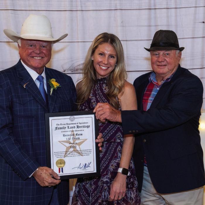 Bob Heinrich and daughter Stacey Heinrich Smatresk accept the Texas Department of Agriculture Family Land Heritage Certificate marking 150 years of continuous agriculture production on the Heinrich Farm near Schulenburg. Presenting the award is Texas Agriculture Commissioner Sid Miller.
