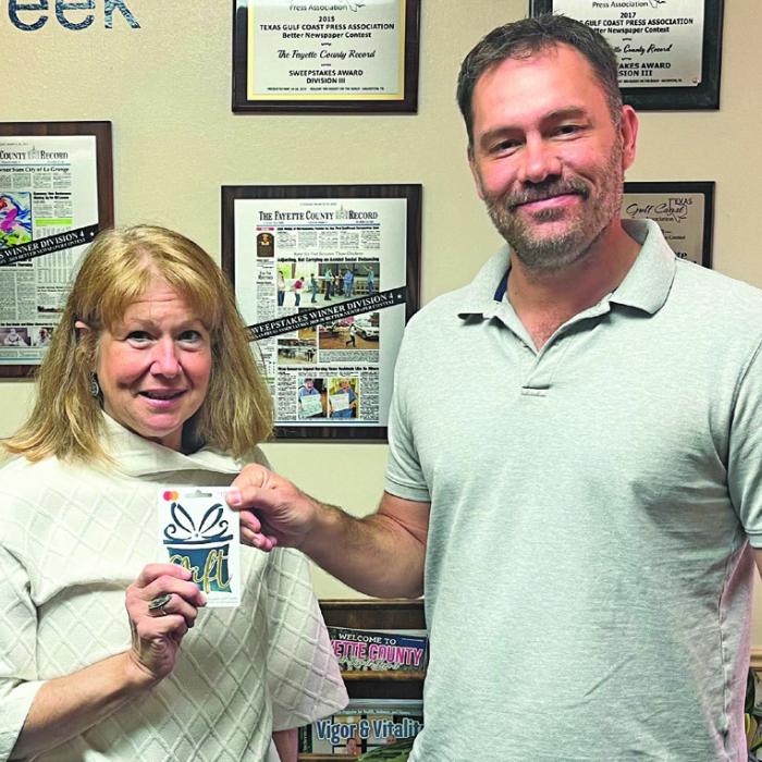 Jennifer Matocha Gillie was the winner in last week’s reader football contest, not only picking all 10 winners but beating out two other perfect ballots in the score prediction tiebreaker. She is shown above left, accepting her $100 from Record editor Jeff Wick.