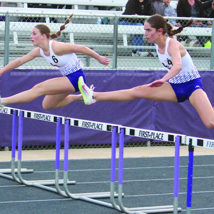 La Grange’s Macie Collier, right, and Campbell Cooper, left, battle for the lead midway through the 100 meter hurdles at the Leopard Relays Thursday. Collier won and Campbell was second. They repeated that finish in the 300 meter hurdles later in the night. Photo by Jeff Wick