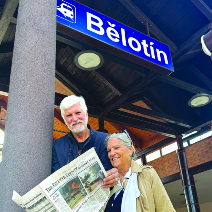 As they enjoy a copy of The Fayette County Record, Sharon and Anthony Haas are pictured visiting Belotin, the Czech Republic, where the Haas family originated from.