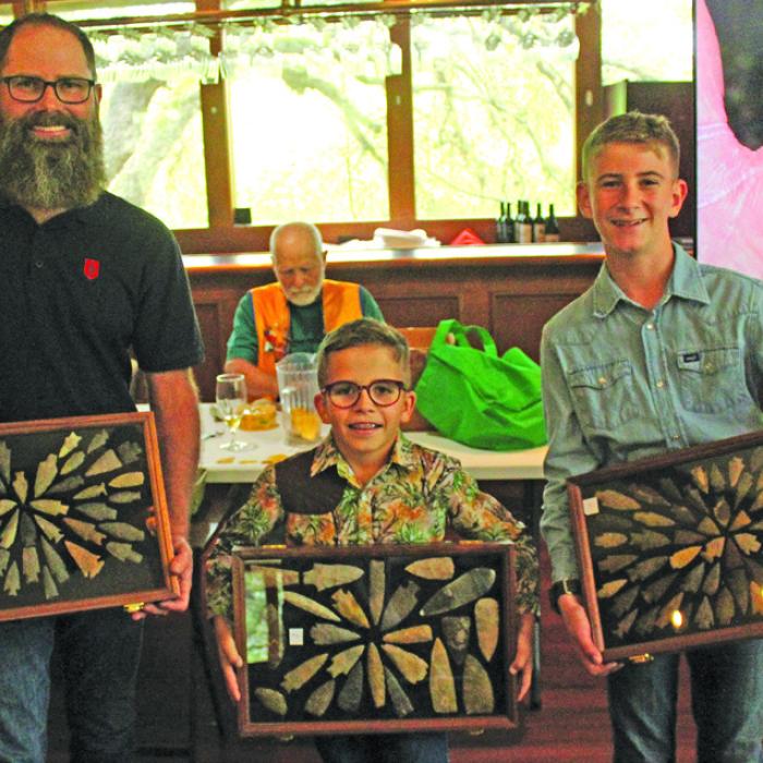 Jeremy Janda and his sons Reed and Will of La Grange, hold up some of the display cases of arrowheads they brought to the La Grange Noon Lions Club Thursday for a talk about how they find these artifacts. Photo by Jeff Wick