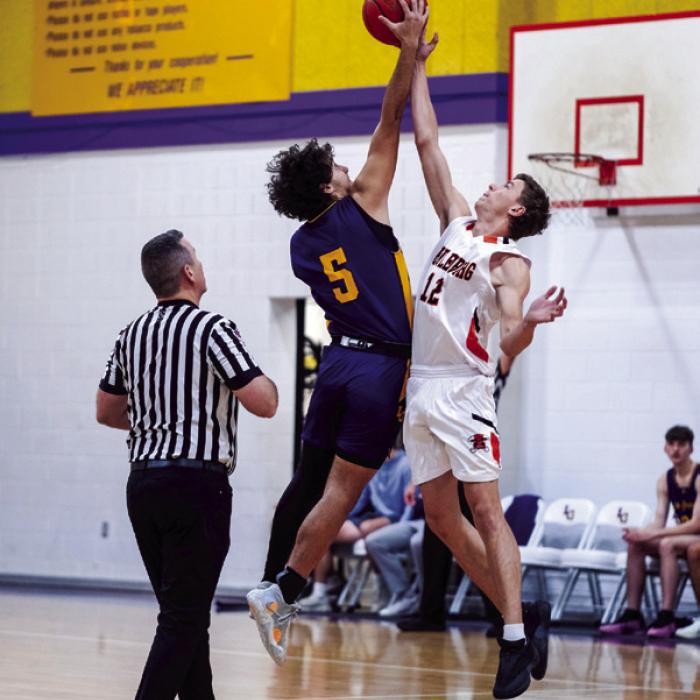 Chris Supak (5) and Van Prihoda (12) fight for the jump ball at the start of Friday’s La Grange vs. Schulenburg matchup in the La Grange Schmeckenfest Basketball Tournament.