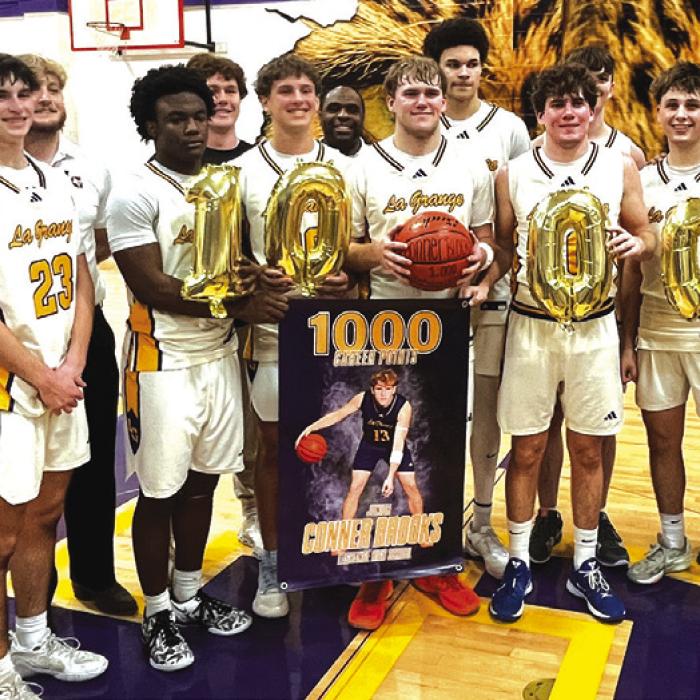 La Grange’s Conner Brooks, center holding the basketball, celebrates with this teammates and coaches after scoring his 1,000th career point Tuesday. Photo by Jeff Wick