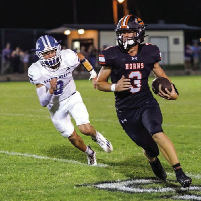 Noska in pursuit. Aaron Janecek cuts upfield with Sacred Heart linebacker Ty Photos by Andy Behlen