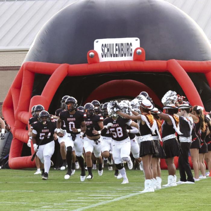 The Schulenburg football team runs out of its pregame tunnel at the start of the game two weeks ago against Rogers. Photo by Audrey Kristynik
