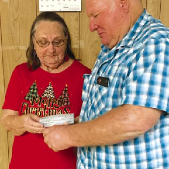 Mary Rauch, treasurer presenting check to Rodney Reed representing Ledbetter Vol. Fire Dept.