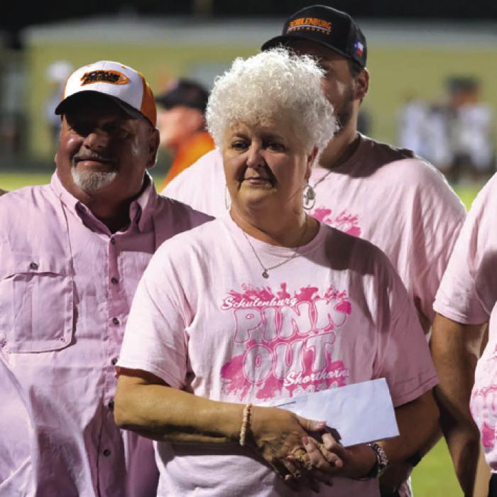 The Schulenburg High Student Council held a “Pink Out” fundraiser to help retired teacher Ann Florus in her fight against breast cancer. They presented her with the proceeds during the football game Friday night. Florus is pictured here with her family and representatives from the student council. Photo by Andy Behlen