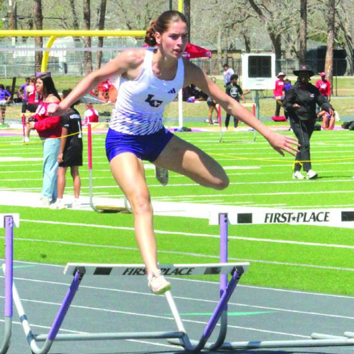 Macie Collier goes over the final hurdle of the 300 meter hurdles last Friday with no one else in sight to win the event. Photo by Jeff Wick