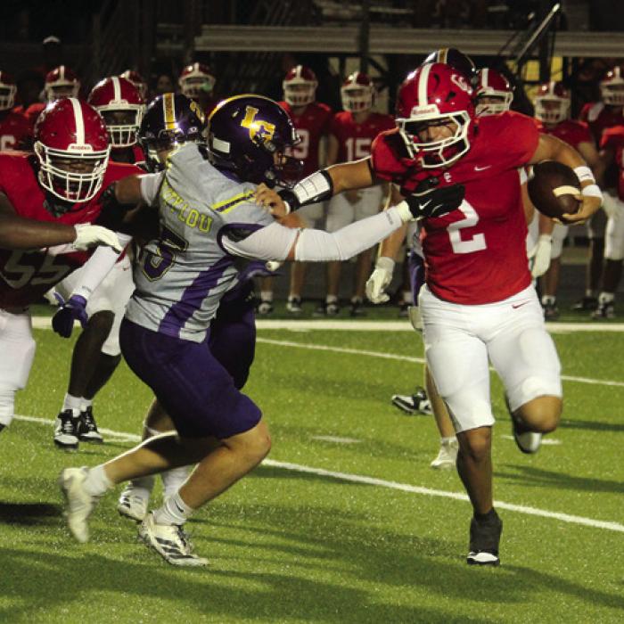 La Grange’s Caleb Norwood tries to corral Columbus quarterback Jack Schobel. Photo by Jeff Wick