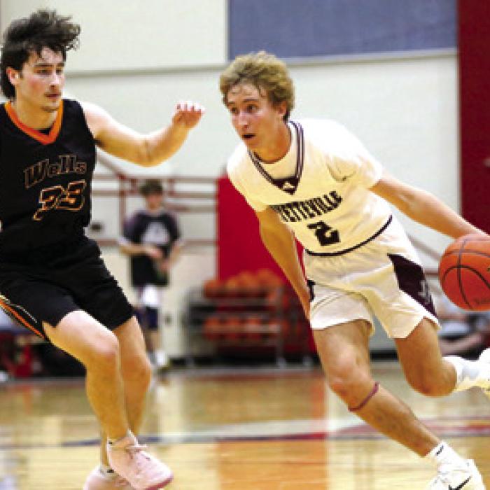 Fayetteville’s Kole Schmitt dribbles past Slade Tarrant of Wells during first-quarter action Tuesday in Madisonville. Photo by Ken Sury