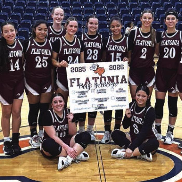The members of the Flatonia girls basketball team celebrate their opening round playoff win Monday in Caldwell.