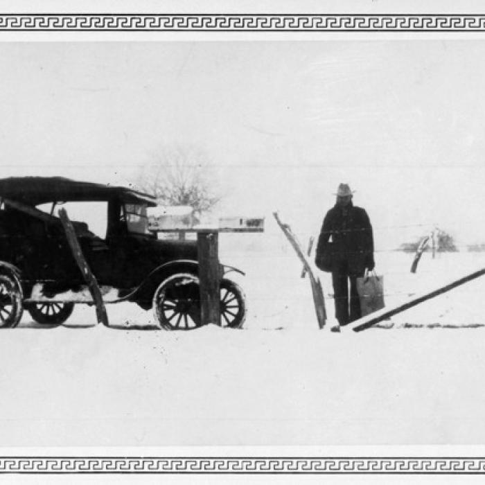 A local mail carrier, possibly John Giese, is shown holding a mail bag and pouch after the Jan. 23, 1926, snowfall.