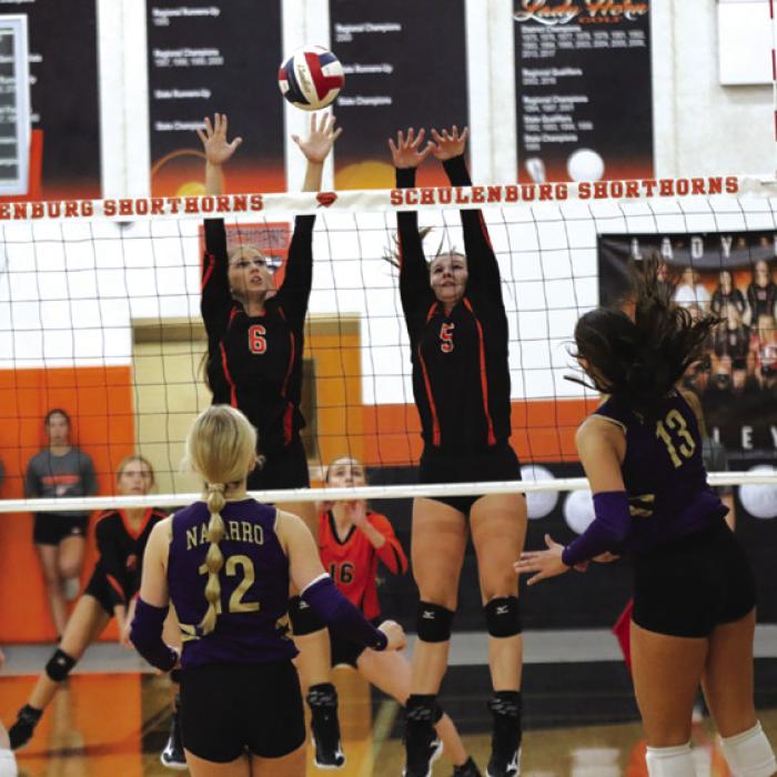 Schulenburg’s Clara Magliolo, left, and Haylee Vacek, right, jump to try to block this Navarro hit Friday. Photo by Audrey Kristynik
