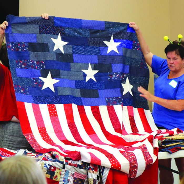 Debbi Gabler with the Quilt of Valor quilts.