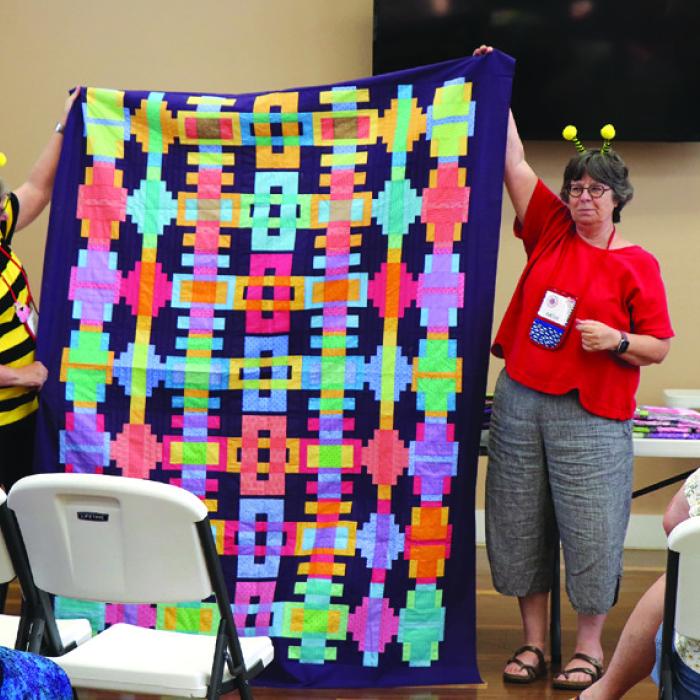 Sandy Courrier and Kathy Babcock with a Day One Quilt.