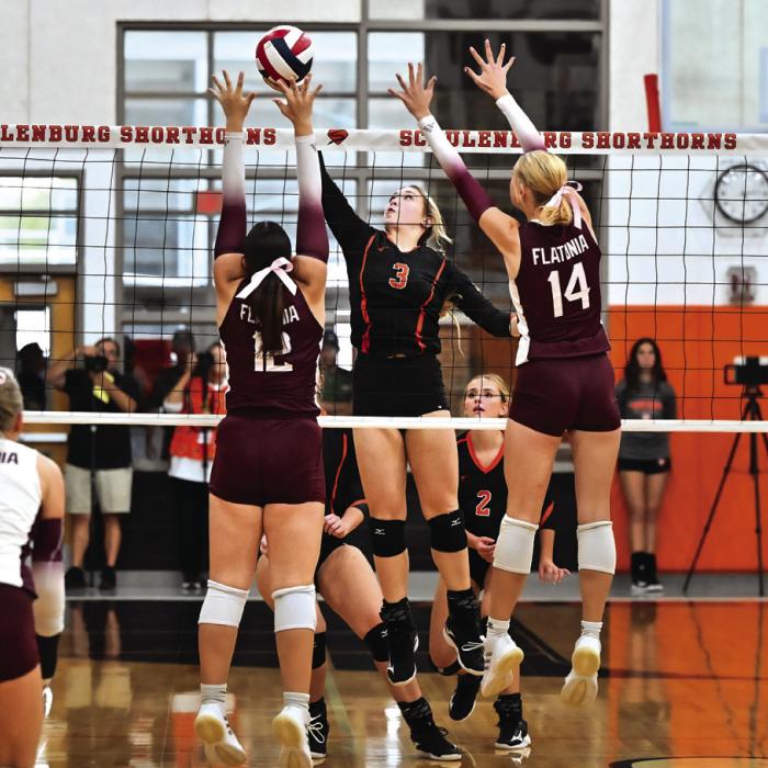 Schulenburg’s Reagan Dusek goes up for a hit while Flatonia’s Abby Uzzell and Quinn Arnett go up for the block. Photo by Stephanie Steinhauser