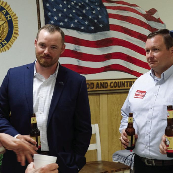 Post-town hall beers in hand, Fayette County Judge run-off candidates Josh Homan, second from left, and Josh Vandever, third from left, chat with attendees after Tuesday’s event. Photo by Andy Behlen