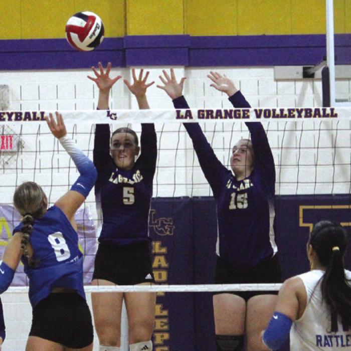 La Grange’s Campbell Cooper and Hannah Gross jump to block a ball in Tuesday’s victory. Photo by Jeff Wick