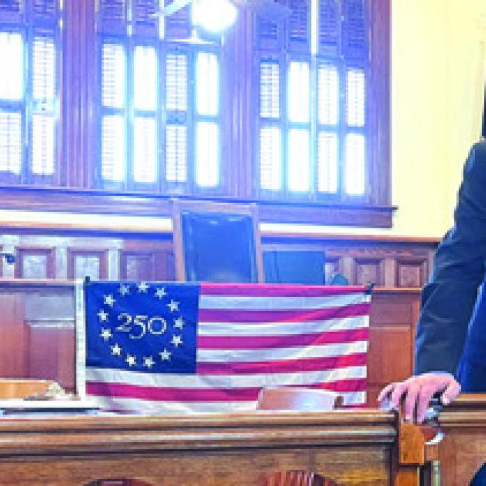 Larry Jackson, left, chair of the America 250 events here in Fayette Co., and Co. Judge Dan Mueller, right, speak at last week’s meeting.