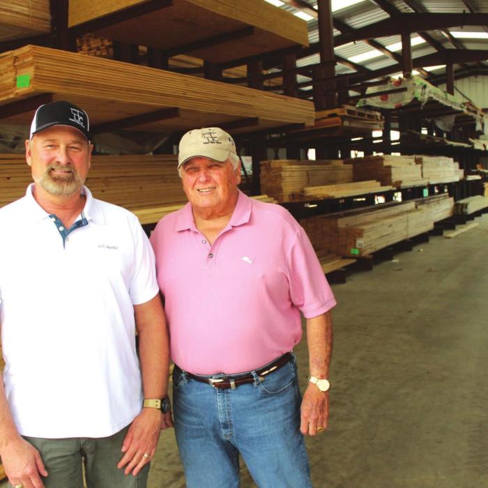 Left to right, Walt Jackson, Farmers Lumber Company General Manager, and Herb Janssen, President of Farmers Board of Directors, stand in one of the lumber supply building in La Grange, similar to one that’s going to be built behind Round Top Mercantile. Photo by Jeff Wick