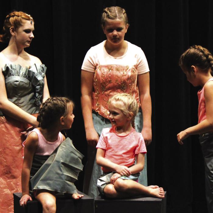 Mermaids (from left), back, Megan Pleger, Mattie Muzny, Alice Muzny and front, Bailey Tousek, and Lucy Martin, all gather round to adjust costumes and pose for a program photo.