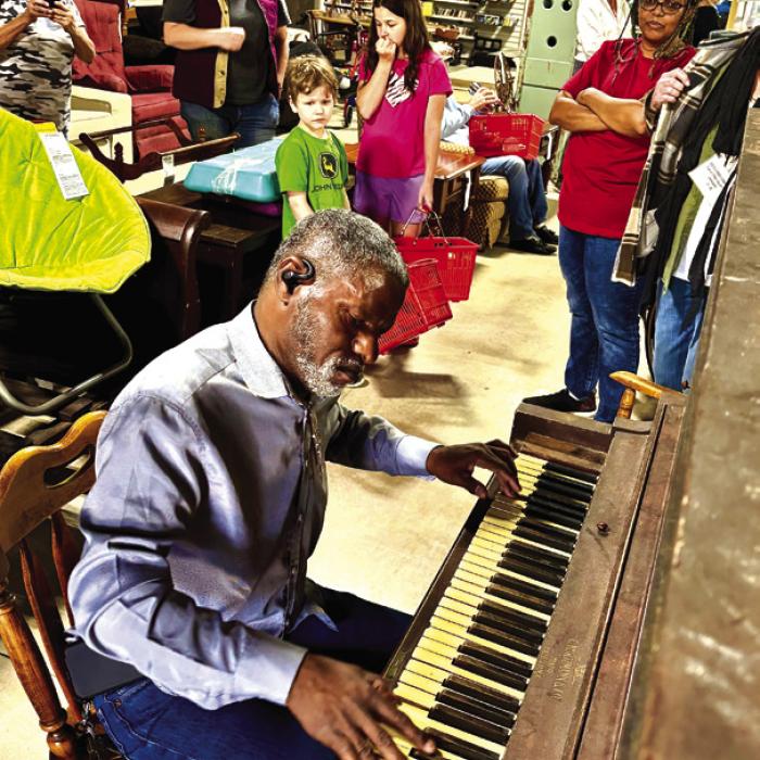 Darryl Leonard of Yoakum perched at an old piano for sale at Second Chance Emporium in La Grange last Saturday and treated customers to some rousing gospel music before heading off to shop for a suit. Photos by Julie Ardery