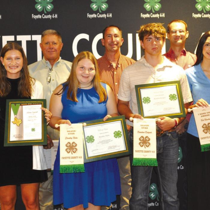 Senior Awards: front from left: Harper Mau, Elena Supak, Brealey Nieto, Kandon Kaspar, Tori Newton, and Logan Poncik; back row: Commissioner Harvey Berckenhoff, Commissioner Jason McBroom, and Commissioner Clint Sternadel, presenting awards.