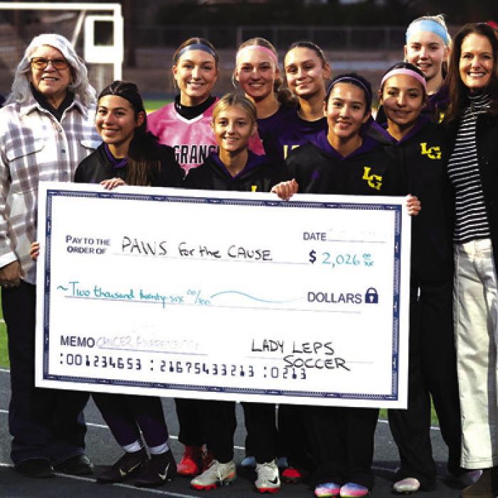 Friday was “Cancer Awareness Night” for the Lady Leps Soccer program. Many members of the Lady Lep program have witnessed cancer firsthand, so the team dedicated the evening to standing with persons and their families battling, surviving or succumbing to cancer. Between the JV and Varsity matches, the Lady Leps presented a donation check for $2,026 to Paws for the Cause. Photo by Katy Michalke