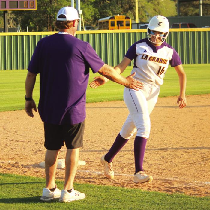 As La Grange’s Melissa Gonzales trots around third base after her home run Tuesday, she gets a high-five from La Grange softball coach Robert Young. Photos by Jeff Wick