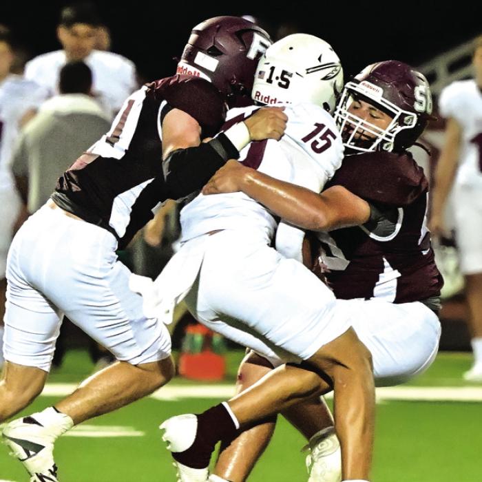 Eli Kubesch (#10) and Gabriel Aguillion (#56) take down the Ganado quarterback Friday night in district opener. The Bulldogs fell to the The Indians and will hit the road to Bloomington this week. Photo by Stephanie Steinhauser