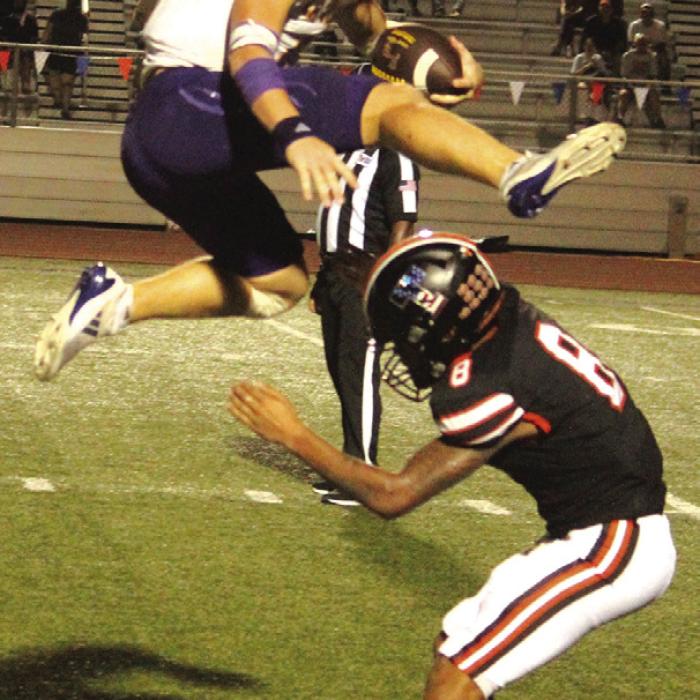 Here’s another angle of the amazing play La Grange quarterback Clayton Cooper made to hurdle this would-be Smithville tackler. Photo by Jeff Wick