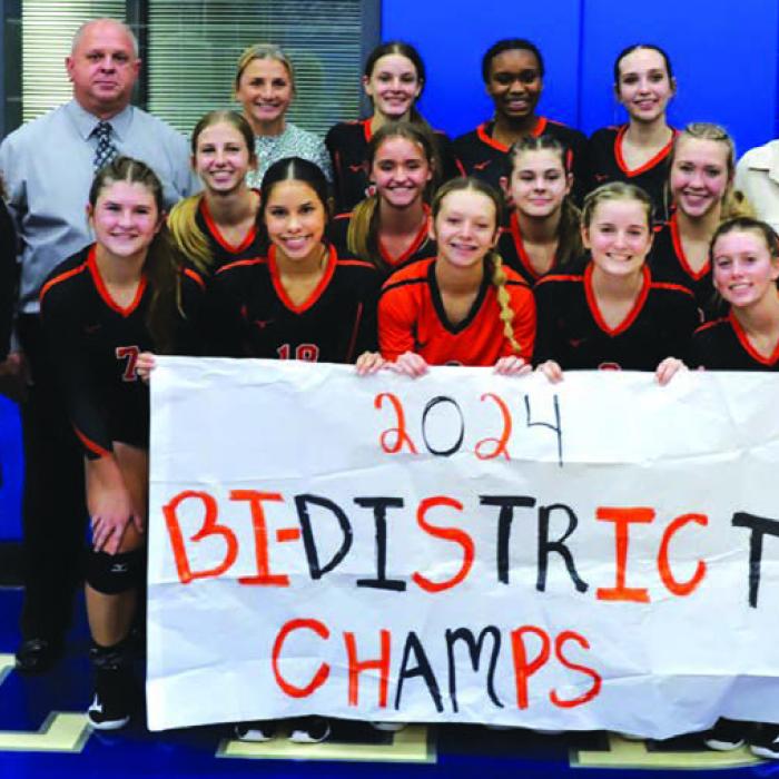The members of the Schulenburg volleyball team pose with a banner proclaiming them Bi-District champs after their victory Monday over Kenedy in the first round of the playoffs. Photo by Audrey Kristynik