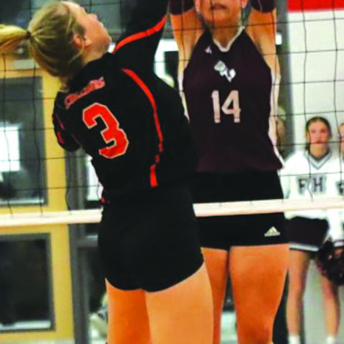 Schulenburg’s Reagan Dusek spikes as Flatonia’s Quinn Arnett readies to block.