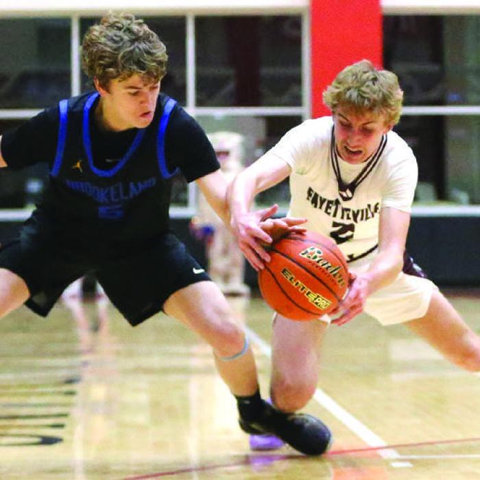 Kole Schmitt of Fayetteville (right) beats Brookeland’s Frank Martindale to the loose basketball in the first quarter Friday night. Photo by Ken Sury