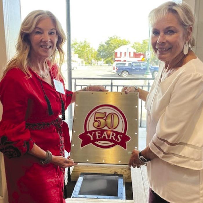Wendy Burks and Vicki Roberts closing the time capsule.