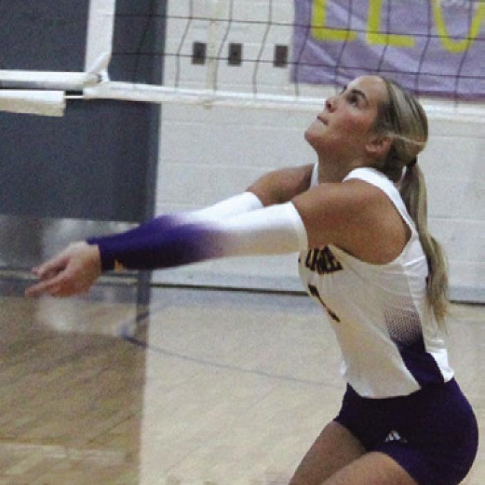 Left: La Grange’s Clara Bundick digs a ball Friday. Right: La Grange’s Faith Greenwood and Brion Williams jump to make a block Friday against Bellville. Photos by Jeff Wick
