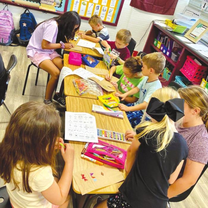 Fourth and fifth graders at Fayetteville ISD helped kindergartners created paper bag teepees Native American symbols.